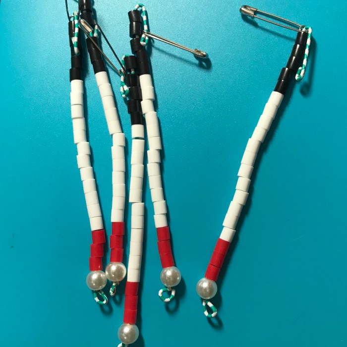 White cane day lapel pins. A miniature version of the guiding cane created with one single pearl bead, One safety pin, one paper clip, and 20 perler beads.